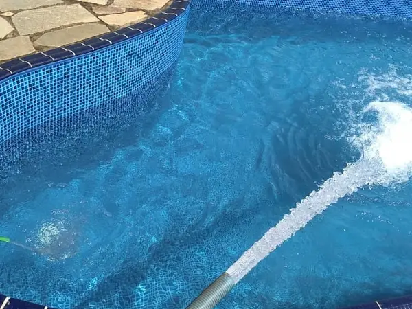 Jato de água enchendo piscina com borda de pedra em São Luís - MA