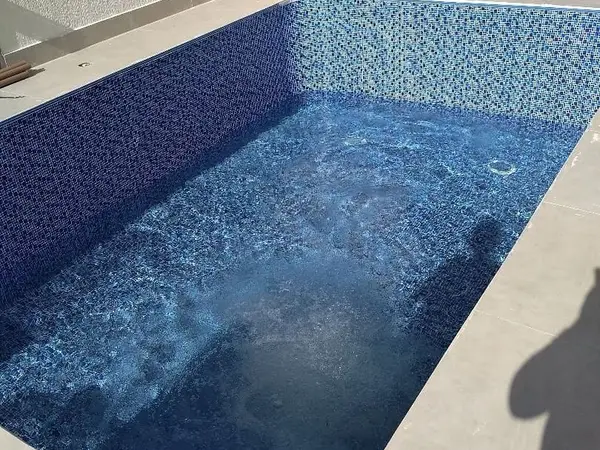 Piscina de pastilha azul escura sendo enchida em São Luís - MA