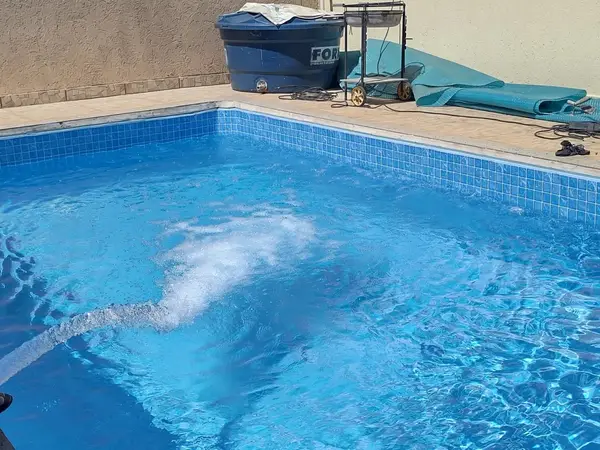 Piscina azul sendo enchida em residência em São Luís - MA